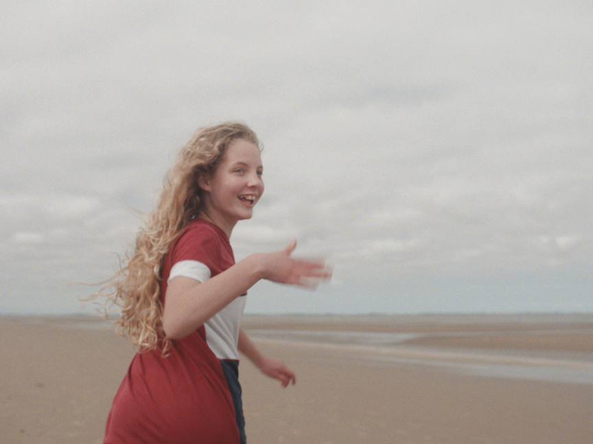 Young girl on beach - still from Any of Us fostering film