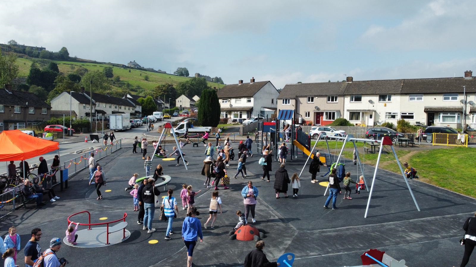 Sunny Bank play area with people enjoying the equipment