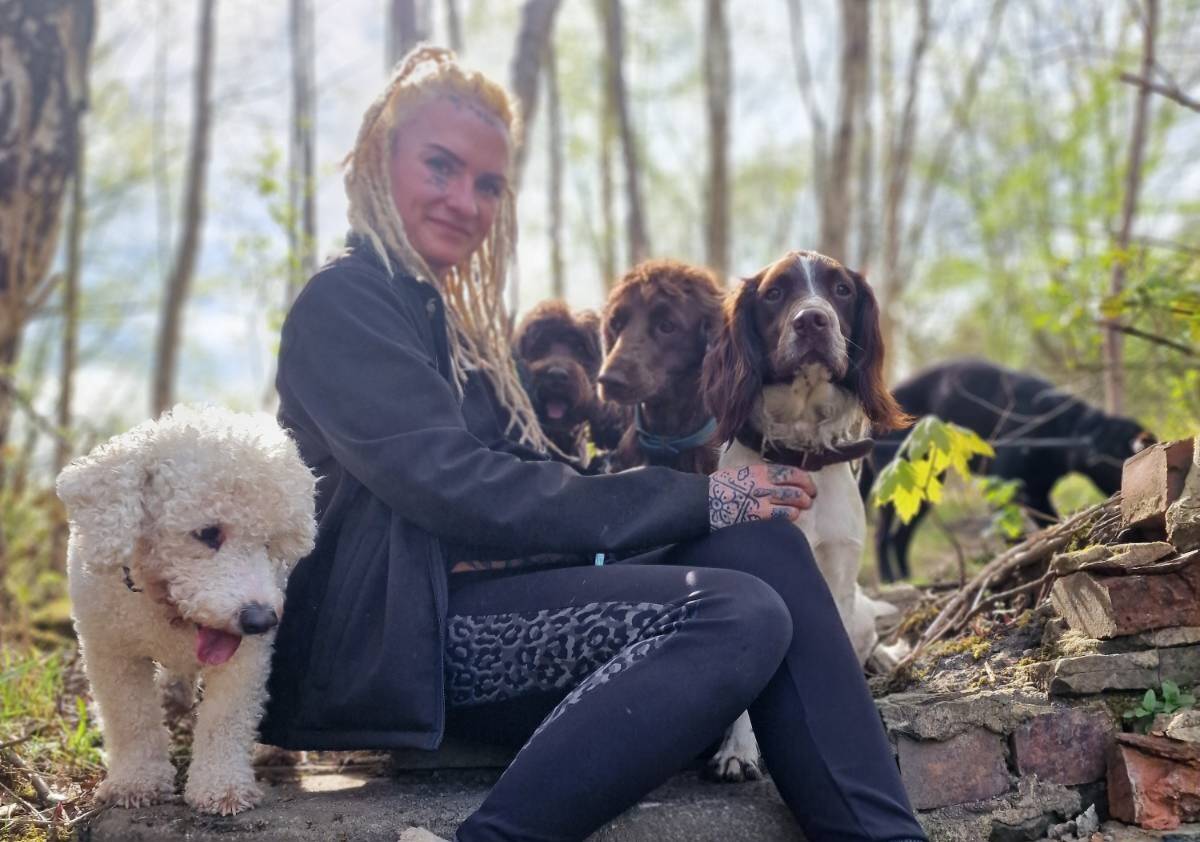 Grace with dogs sat in woods