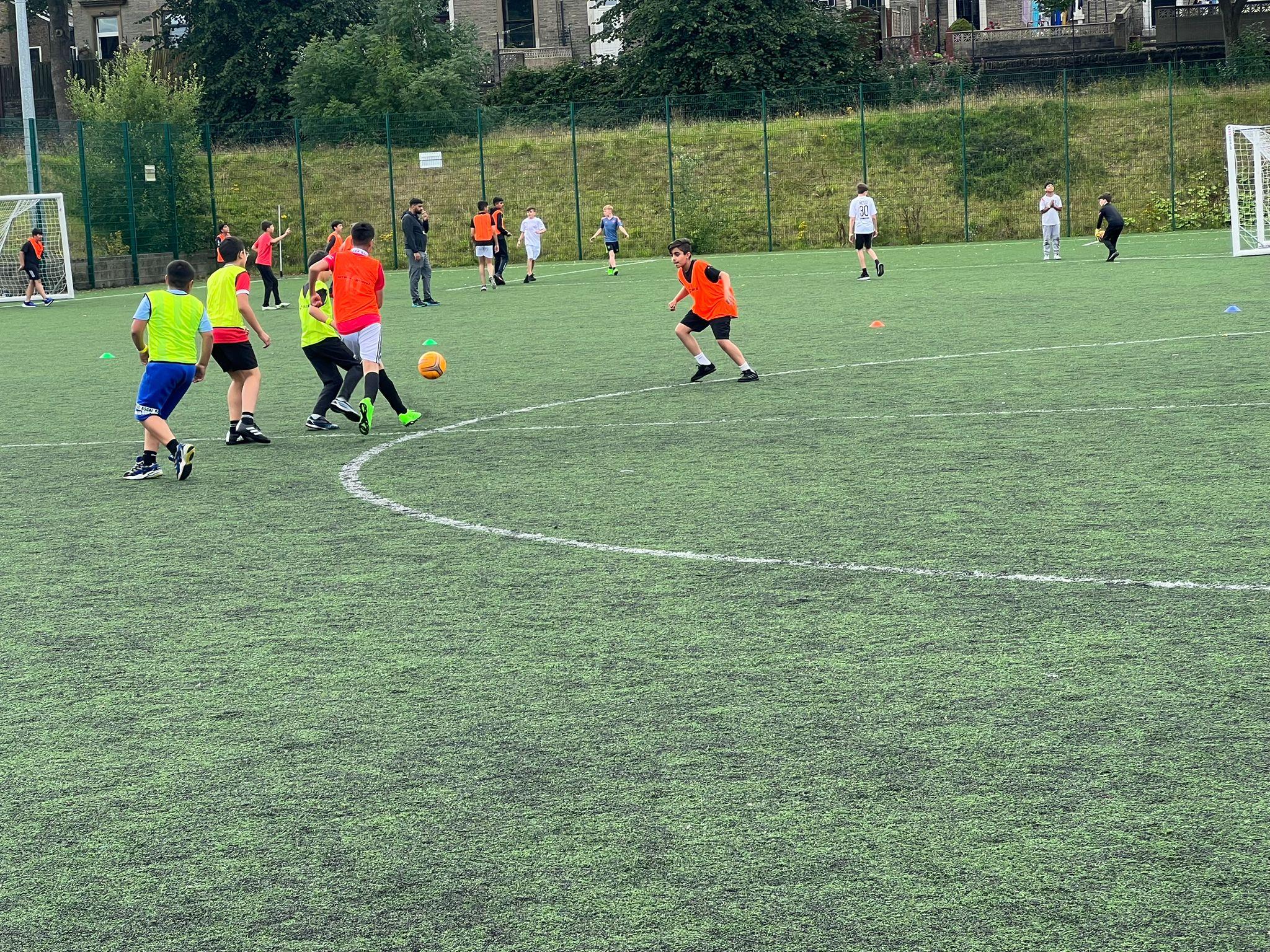 Young people playing football as part of summer activity sessions