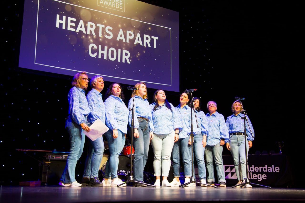 The Ukrainian choir, Hearts Apart, performing on a stage.