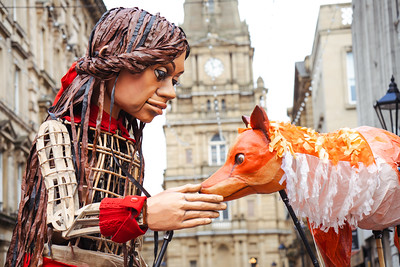 Little Amal puppet with fox puppet outside Halifax Town Hall