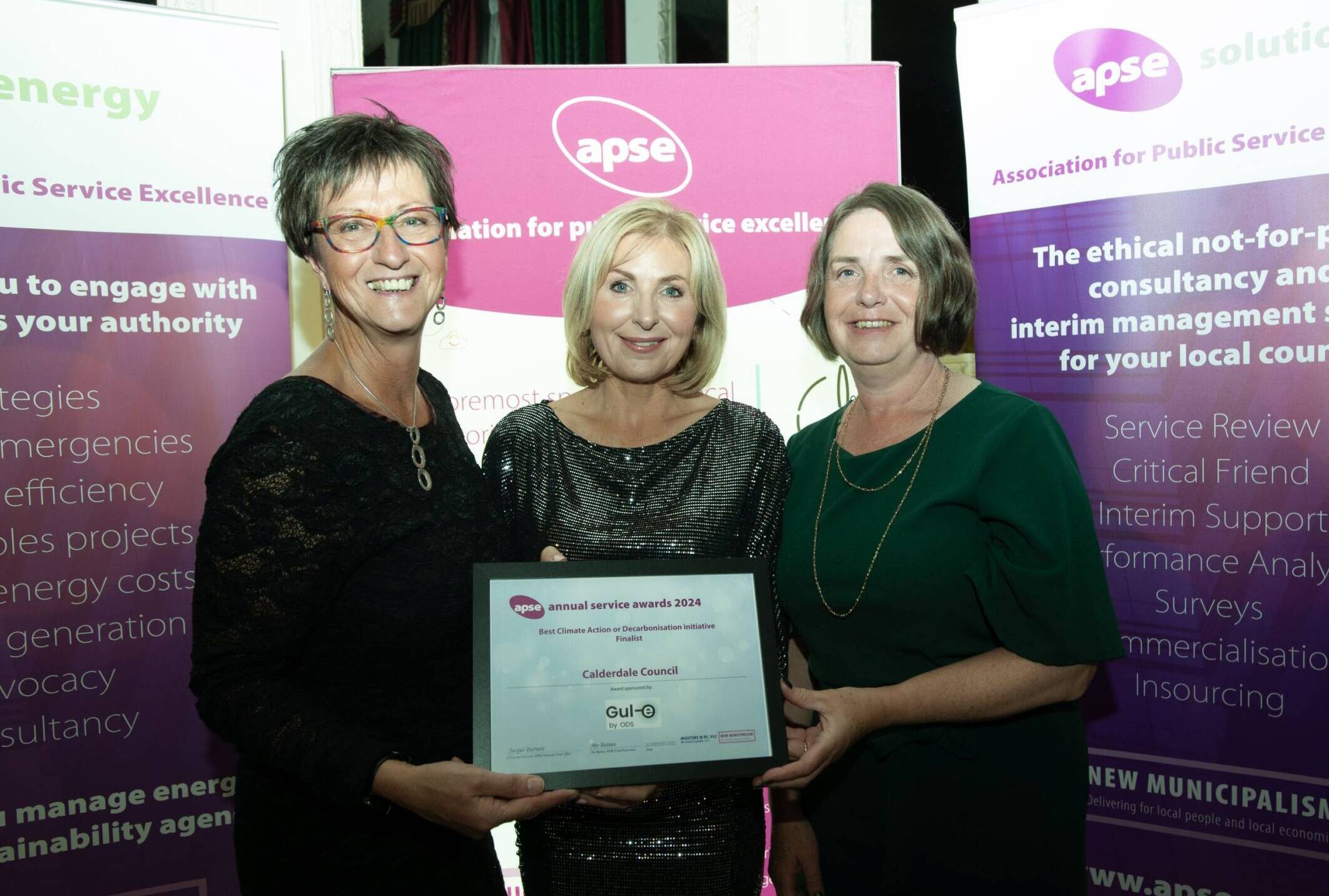 Receiving the APSE finalist award. Three people with certificate and banners