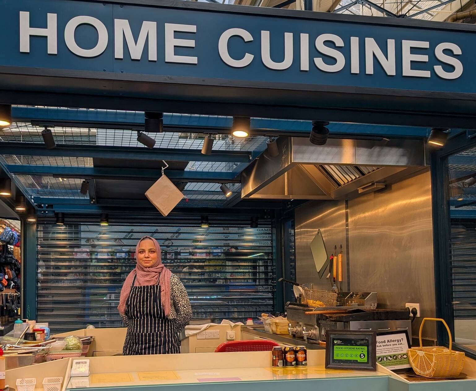 Woman at stall in Halifax Borough Market, showing modern new style of stall