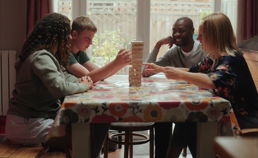Family around a table playing Jenga