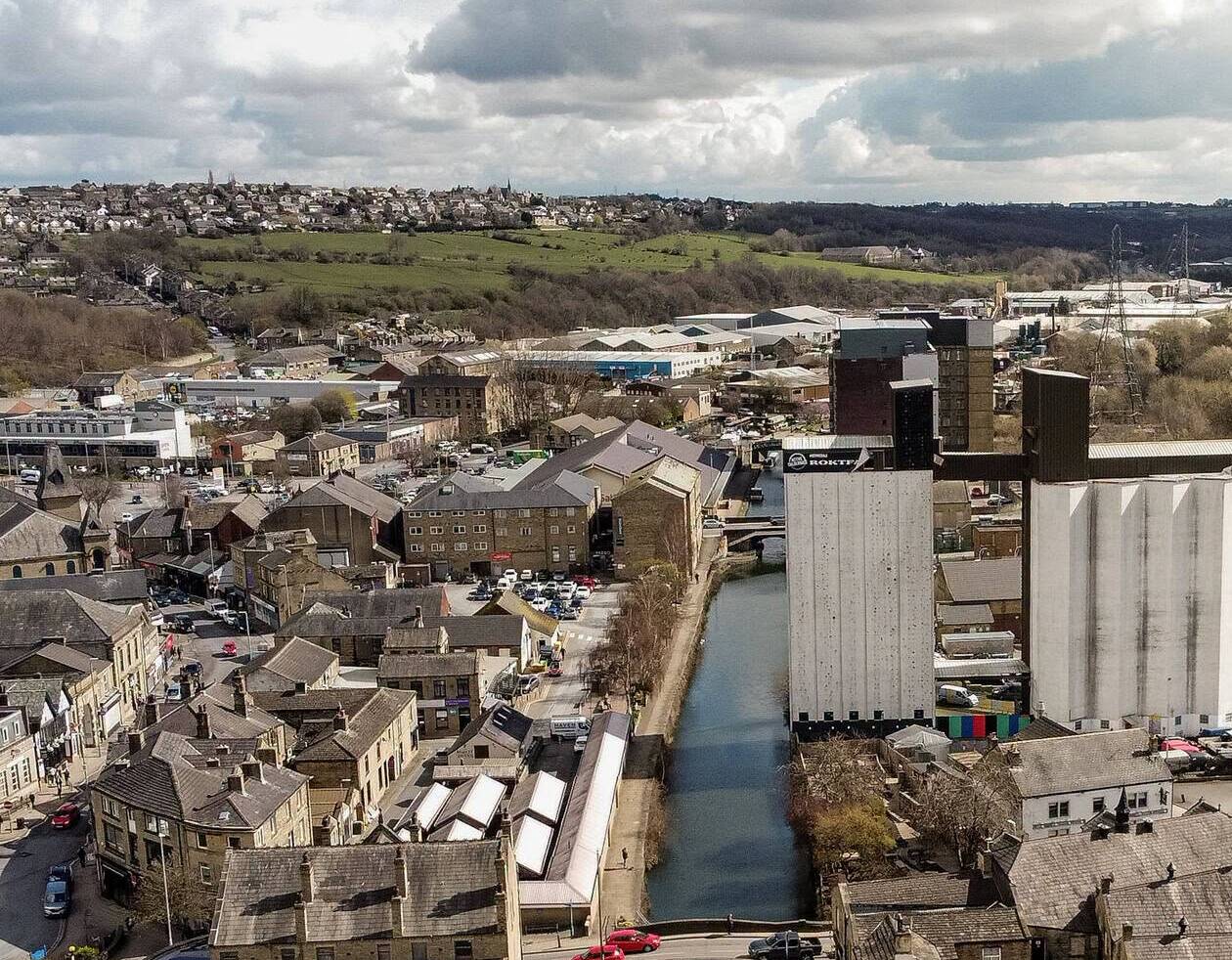 Brighouse town centre from above, showing buildings, hills and the canal.